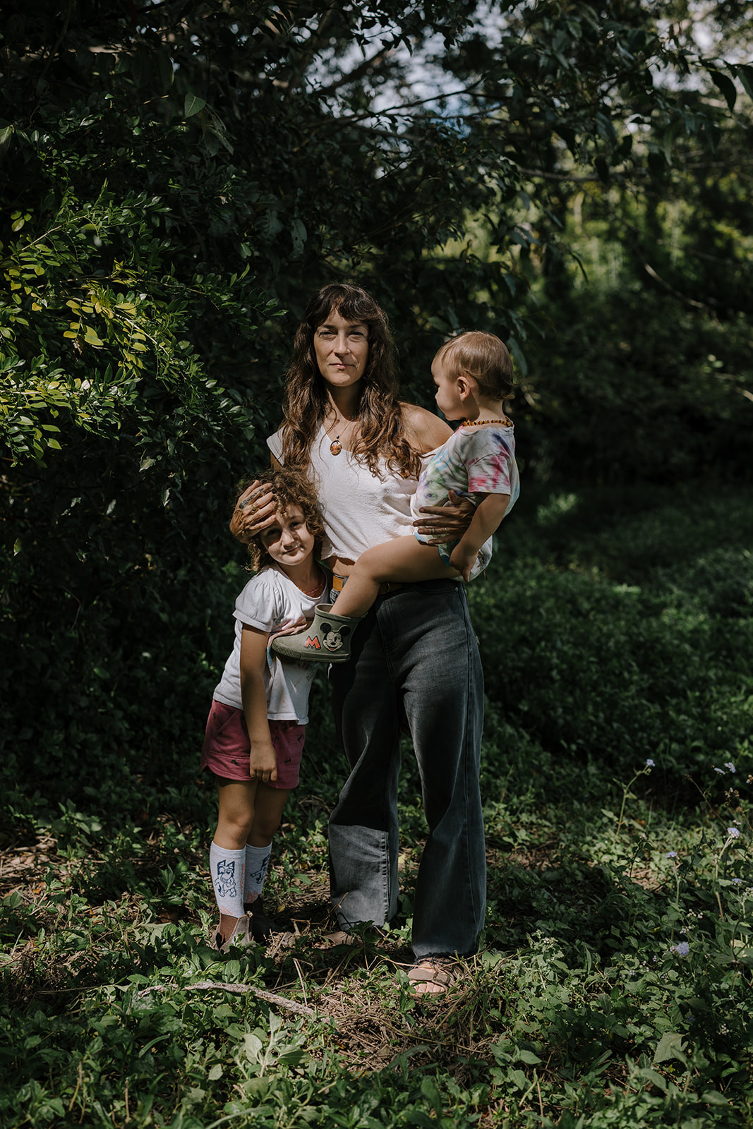 Chrissy Beth with both of her children in their sunlit garden.